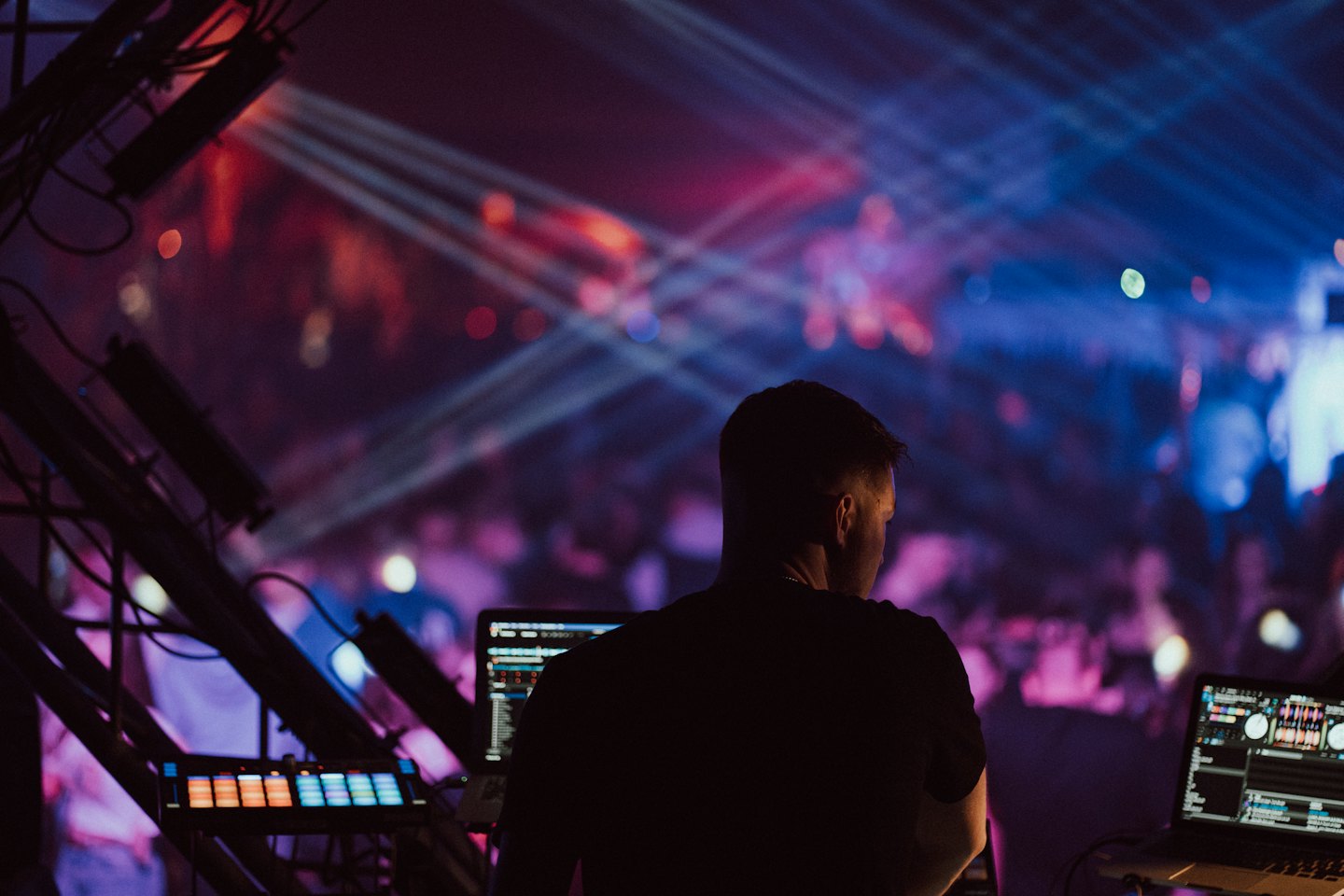 DJ operating a mixing console on stage during a performance.